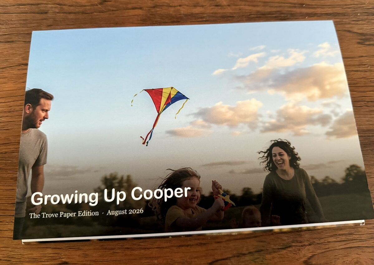 The Paper Edition cover — 'Growing Up Cooper', a family flying a kite at sunset